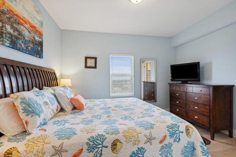 Habitación principal con cama doble y decoración marinera en Stunning Gulf View Condo con acceso directo a la playa