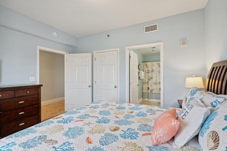 Habitación principal con decoración marinera y baño en suite del condo Gulf View con acceso directo a la playa