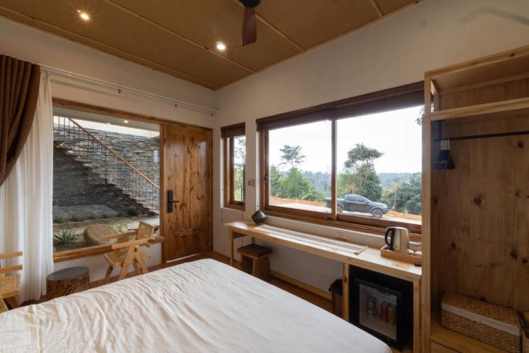 Habitación doble con escritorio de madera y ventana con vistas al bosque en MăngDiang Boutique Hotel