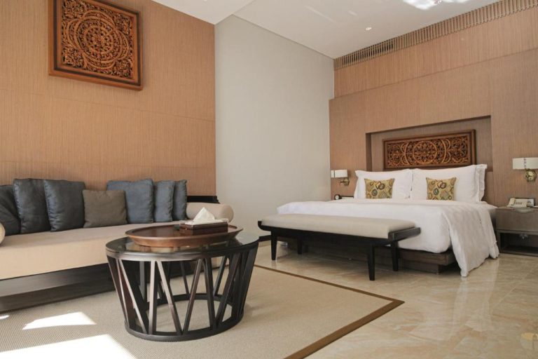 Lujosa habitación suite con cama king y tallado balinés en The Anvaya Beach Resort Bali