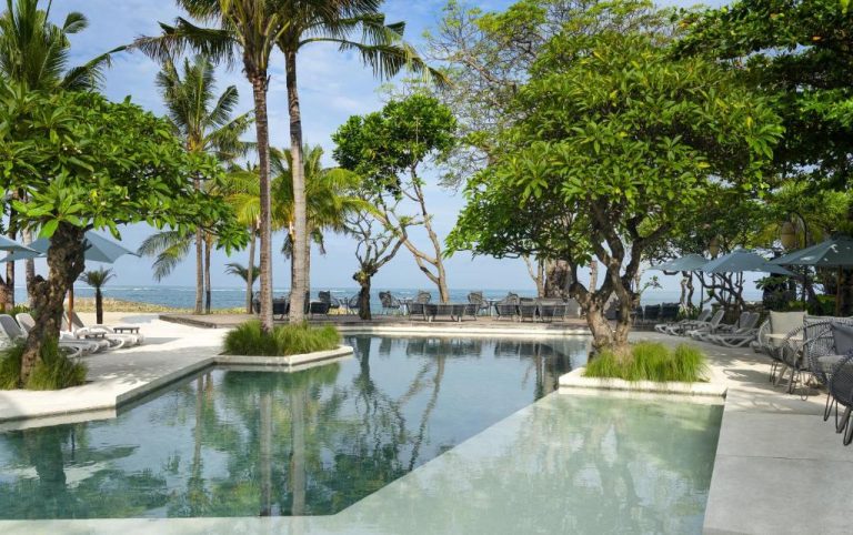 Piscina exterior con vistas al mar y palmeras tropicales en The Anvaya Beach Resort Bali