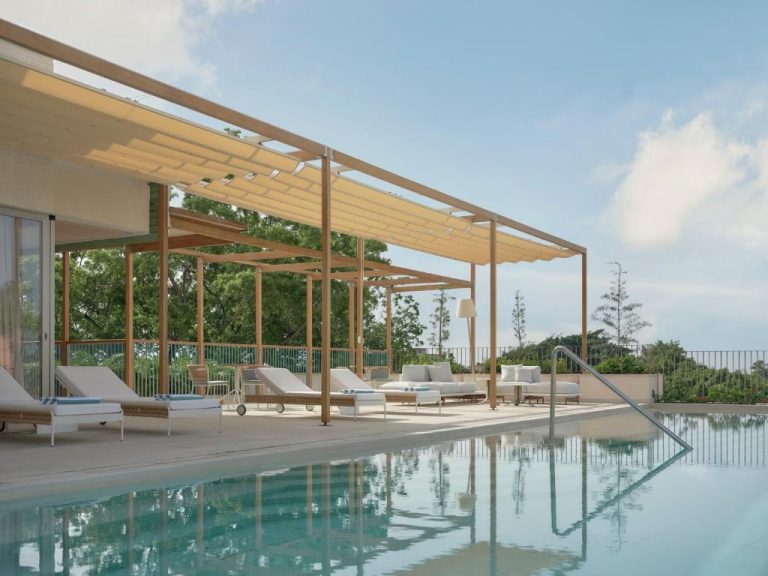 Piscina exterior con tumbonas y pérgola de madera en Kimpton Las Mercedes by IHG