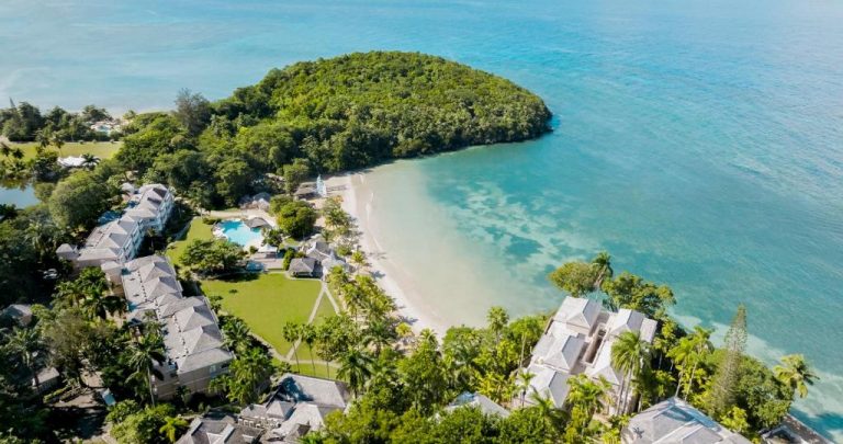Vista aérea del resort Couples Sans Souci con playa privada, piscina y vegetación tropical en Jamaica