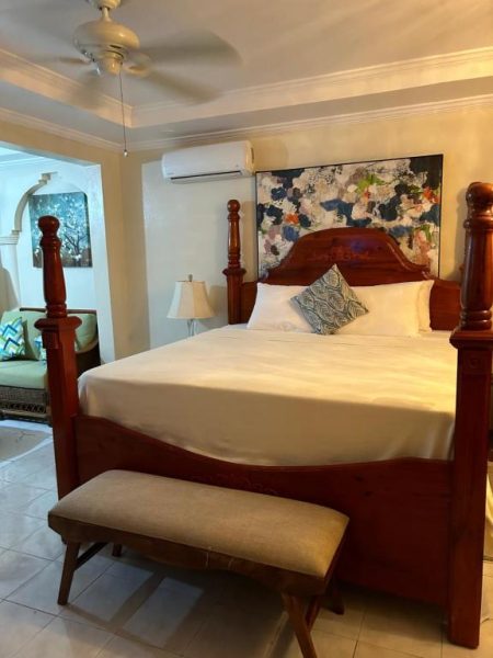 Habitación con elegante cama de dosel de madera y decoración artística en Rayon Hotel