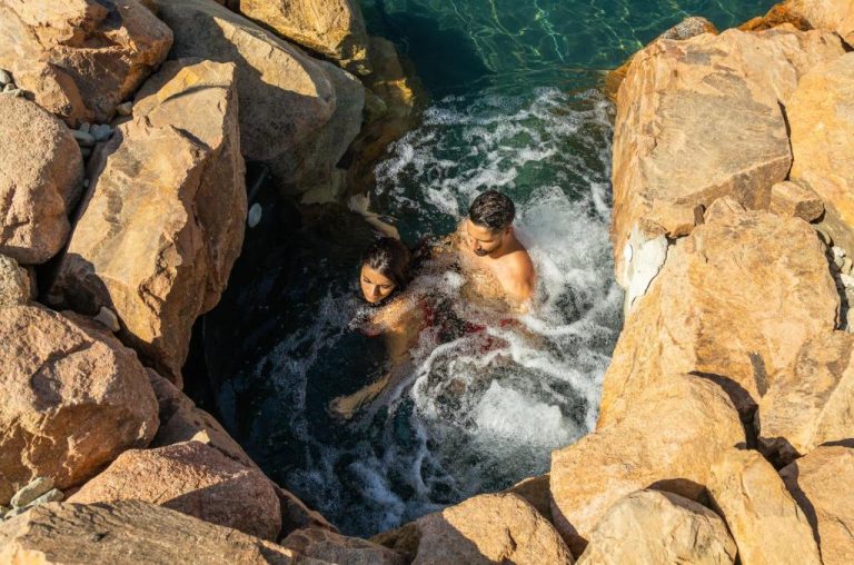 Pareja disfrutando del spa natural entre rocas en Corte Bianca Adults Only & SPA Bovis Hotels