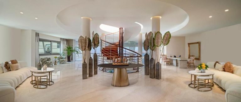 Lujoso lobby del Ailla Yalıkavak con escalera de caracol y decoración elegante en blanco