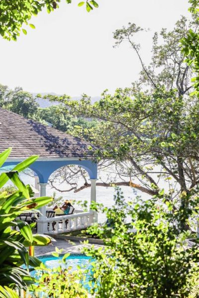 Gazebo colonial con terraza y vistas al mar en Jamaica Inn, rodeado de vegetación tropical