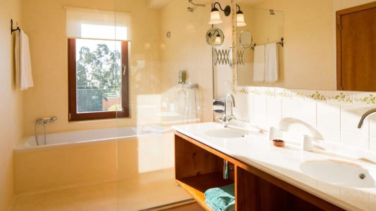 Baño amplio con doble lavabo, bañera y cabina de ducha en el Hotel Atrio