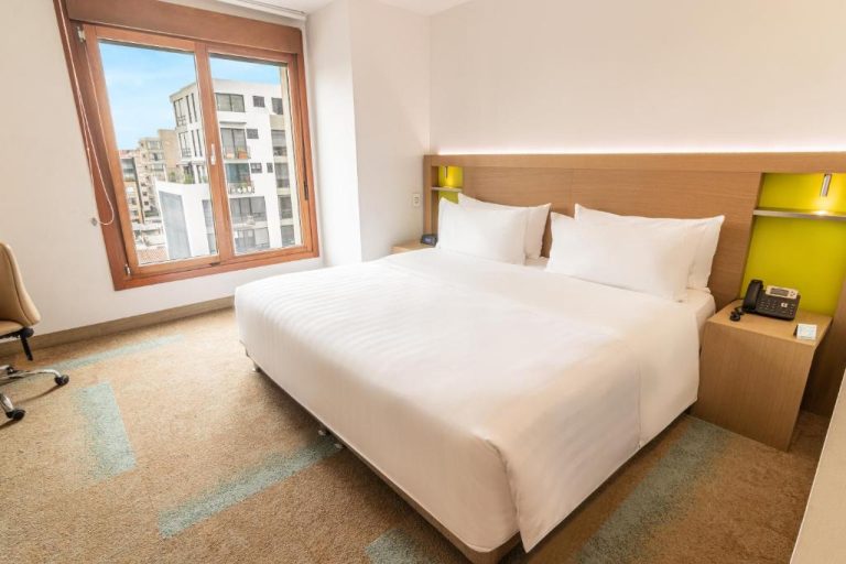 Habitación con cama king size y vista a la ciudad en Biohotel Organic Suites Bogotá Usaquén