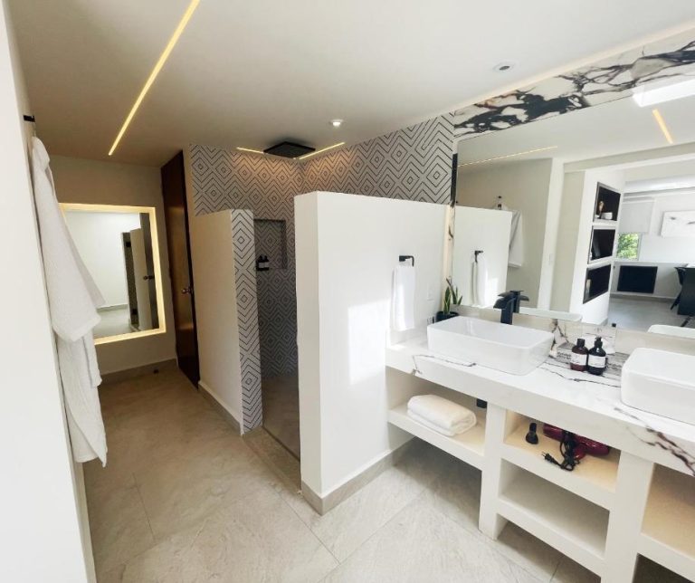 Baño de lujo con doble lavabo en mármol y ducha de diseño en Marisol Hotel Boutique