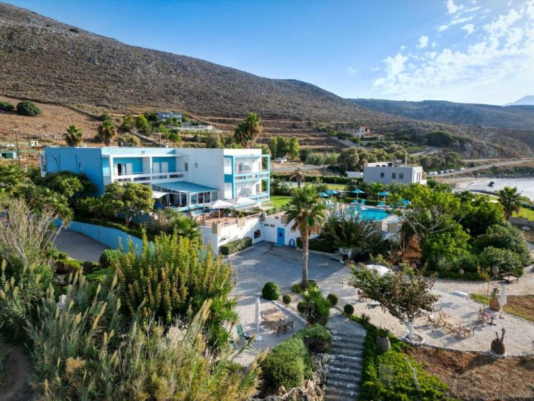Vista aérea de Kanakis Blue Beach Apartments con piscina exterior, jardines y montañas al fondo en Creta