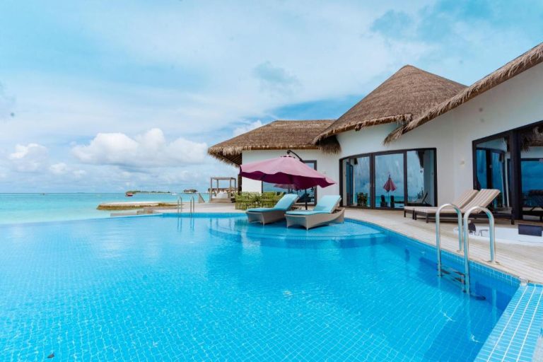Piscina infinita con vistas al océano en NOOE Maldives Kunaavashi, villa sobre el agua con bungalows de paja