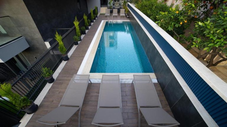 Piscina exterior con tumbonas y jardín del Stile Suite Marine Hotel