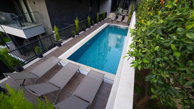 Piscina exterior privada con tumbonas y jardín de naranjos en Stile Suite Marine Hotel