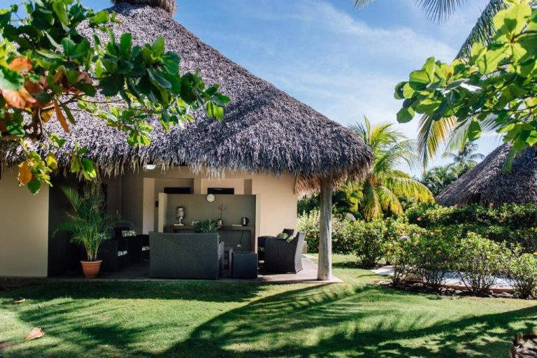 Bungalow con techo de palapa y jardín tropical en Fiesta Resort All Inclusive Costa Rica