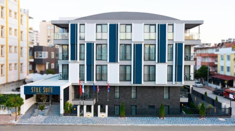 Fachada exterior moderna del Stile Suite Marine Hotel con diseño en azul y blanco y banderas internacionales