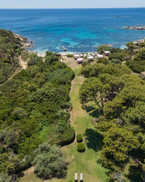 Vista aérea del jardín y playa privada del Hotel Cala Caterina con aguas turquesas en Cerdeña