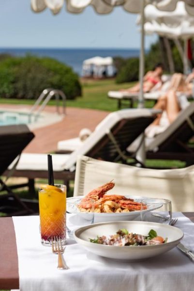 Almuerzo con mariscos y cóctel junto a la piscina exterior del Hotel Cala Caterina con vistas al mar