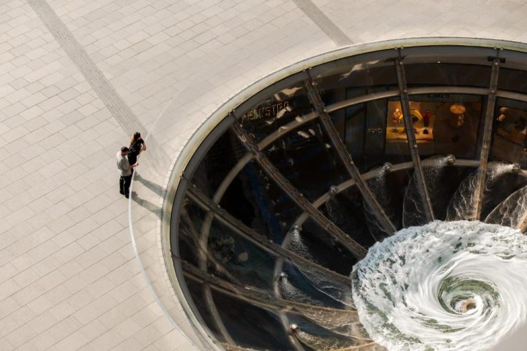 Vista aérea de la fuente vórtex en espiral del hotel Marina Bay Sands con turistas en Singapur