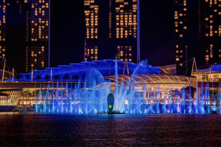 Espectáculo nocturno de fuentes luminosas con luces azules frente al Marina Bay Sands en Singapur