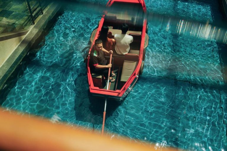 Paseo en góndola por el canal interior del Marina Bay Sands con gondolero remando en aguas turquesas
