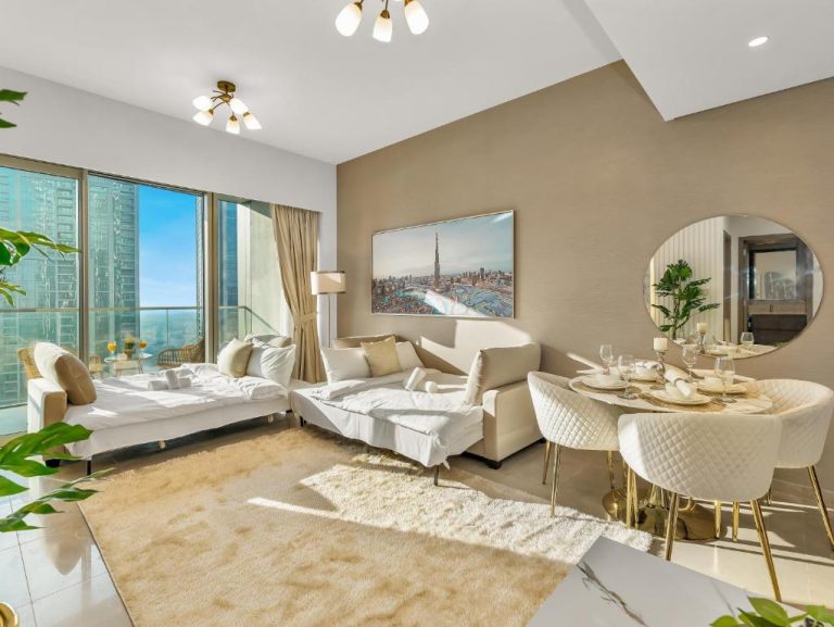 Salón comedor de lujo con vistas al Burj Khalifa y sofás blancos en apartamento cerca de Dubai Mall