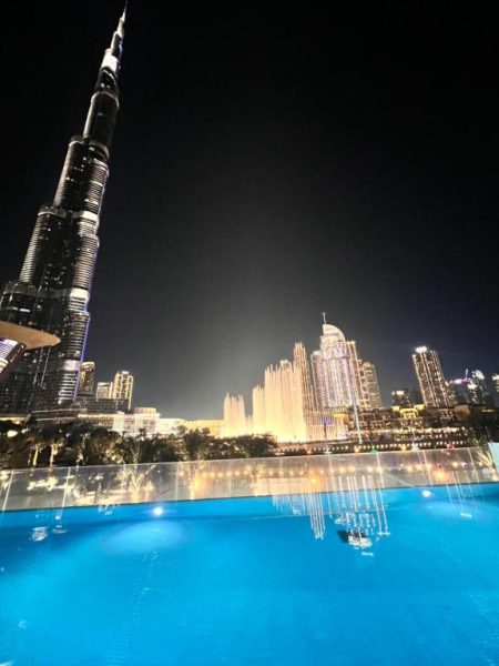 Piscina infinita con vistas nocturnas al Burj Khalifa y fuentes de Dubái en Luxury 1BR Dubai Mall