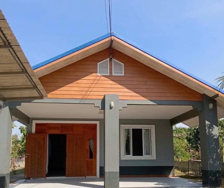 Fachada exterior del Coco Residence Si Saket con techo azul y revestimiento de madera naranja