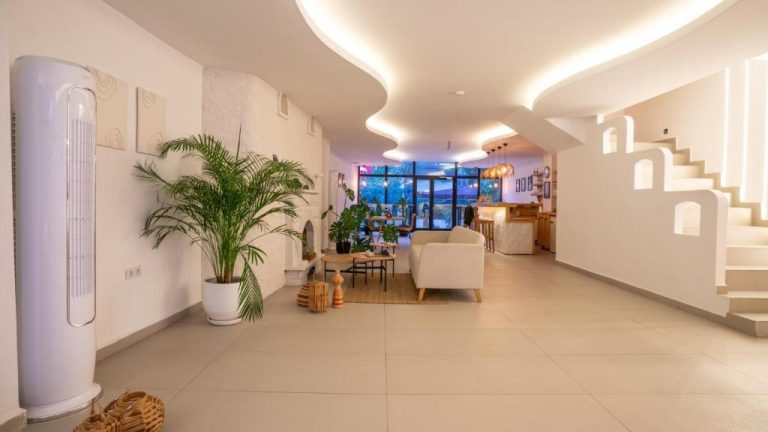 Amplio salón moderno con iluminación indirecta y plantas tropicales en el hotel Audo Local