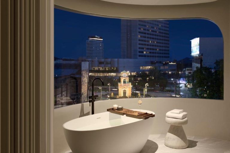 Bañera exenta con vistas nocturnas a la ciudad y torre del reloj en Arco Phuket Town