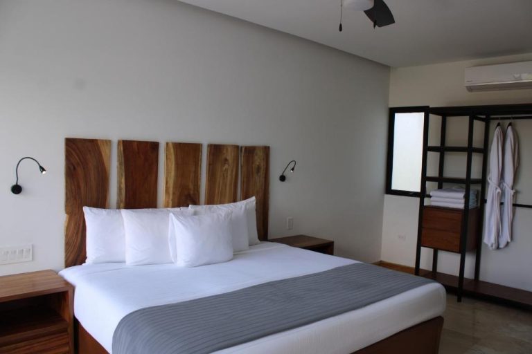 Habitación doble con cabecero de madera natural y ropa de cama blanca en Hotel B10 Distinctive Hotel
