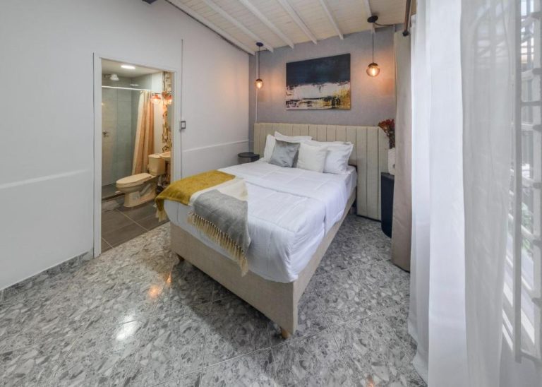 Habitación doble con cama matrimonial y baño privado en Hotel Hola Medellín