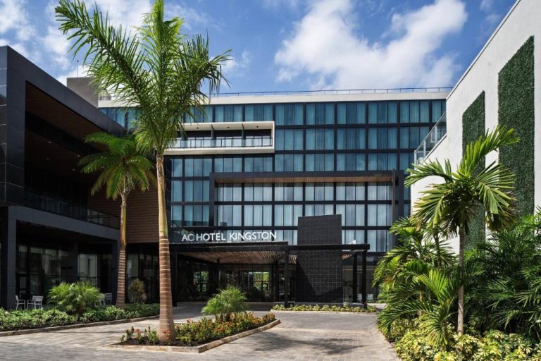 Fachada exterior del AC Hotel by Marriott Kingston Jamaica con palmeras y jardines tropicales