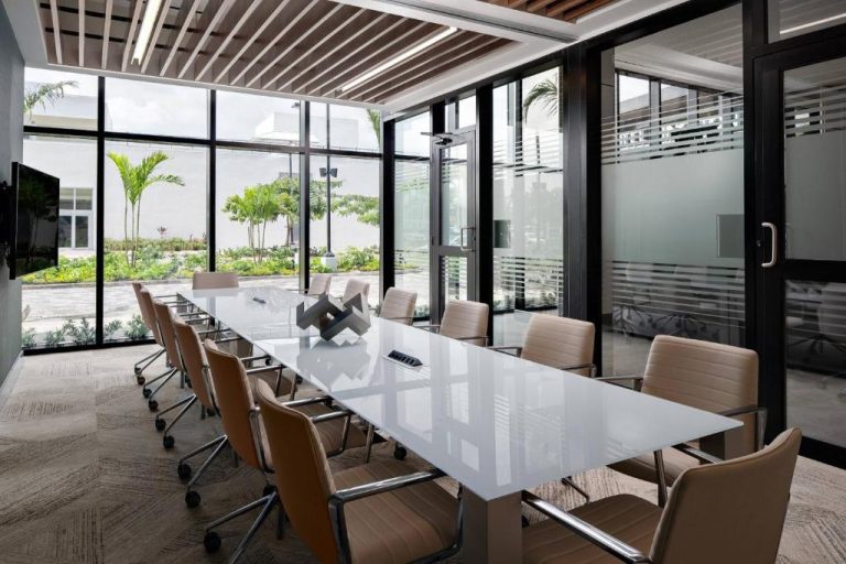 Sala de reuniones moderna con mesa blanca y sillas de cuero en AC Hotel by Marriott Kingston Jamaica