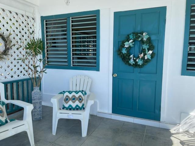 Porche de entrada con puerta turquesa y corona decorativa en el hotel Catcha Falling Star