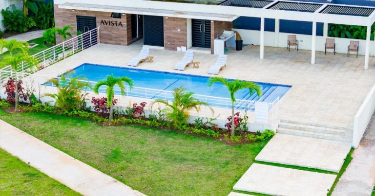 Piscina exterior con tumbonas y jardín tropical del Avista Premium Studio con vista al pool