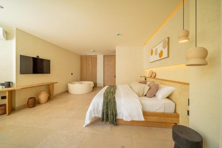 Suite de lujo con cama doble, bañera exenta y televisión en el Moabi Hotel