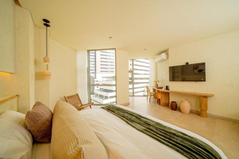 Habitación doble con cama king, escritorio de madera y vista a edificios en Moabi Hotel