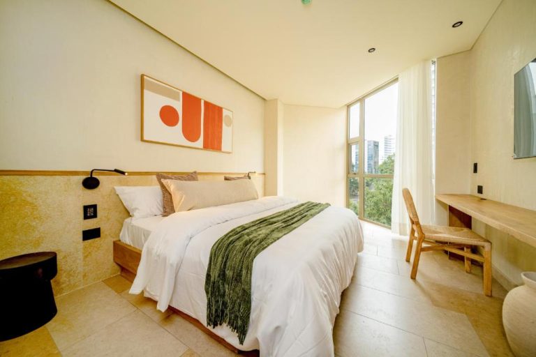 Habitación doble moderna con cama king y ventanal con vista a la ciudad en Moabi Hotel