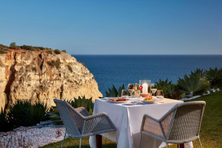 Mesa romántica con cena al aire libre y vistas al mar y acantilados en Tivoli Carvoeiro Algarve