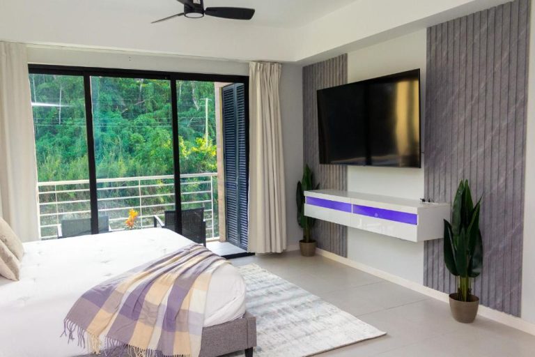 Habitación moderna con cama, TV y terraza con vistas al jardín en Premium Studio with Pool View