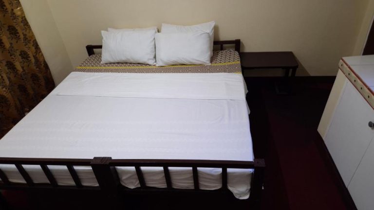 Habitación con cama doble y sábanas blancas en Cool Martin Family Hotel and Resort