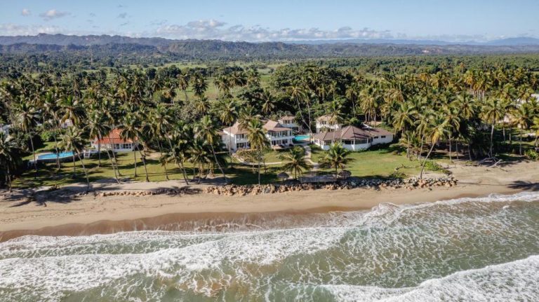 Vista aérea de Las Canas Beach Retreat con villas frente al mar rodeadas de palmeras tropicales