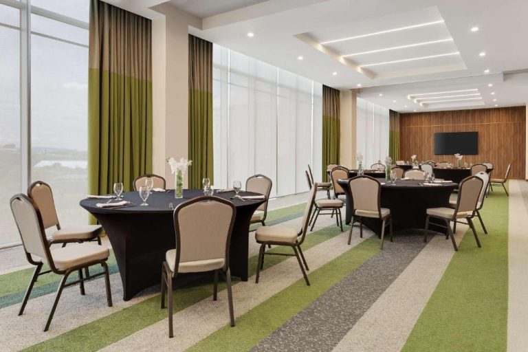 Salón de eventos con mesas redondas y sillas elegantes en el Hilton Garden Inn San José Airport City Mall