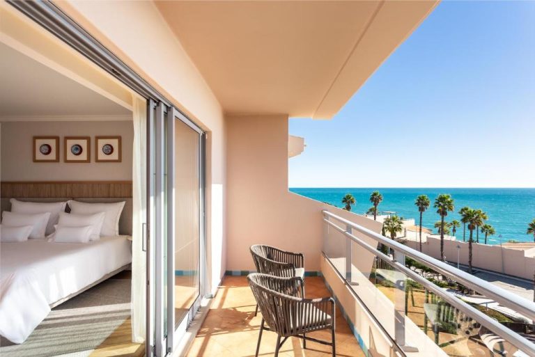 Habitación con balcón y vistas al mar turquesa en Grande Real Santa Eulalia Resort & Hotel Spa