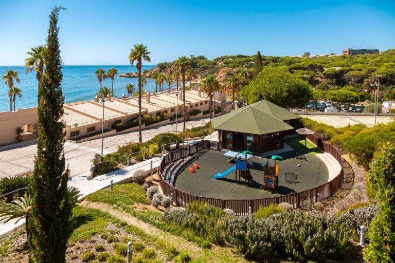 Zona de juegos infantiles con toboganes y gazebo en Grande Real Santa Eulalia Resort frente al mar