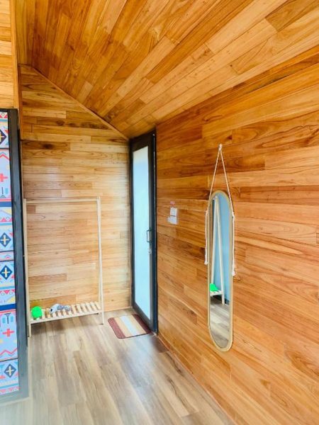 Interior de cabaña de madera con espejo y puerta de cristal en hotel MANG DEN Romantic