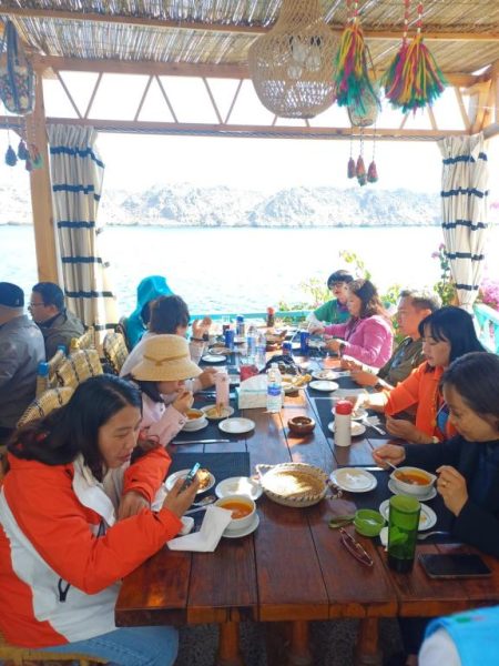 Grupo de turistas almorzando en el restaurante con vistas al Nilo del Miskaa Nubian House