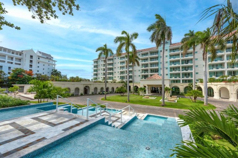 Piscina exterior con jacuzzi y jardines tropicales del resort Sandals Dunns River en Jamaica