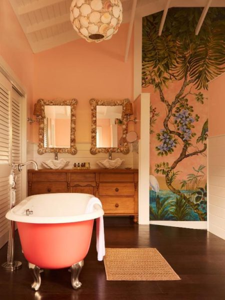 Baño tropical con bañera exenta coral y mural botánico en Coral Sands Inn & Cottages